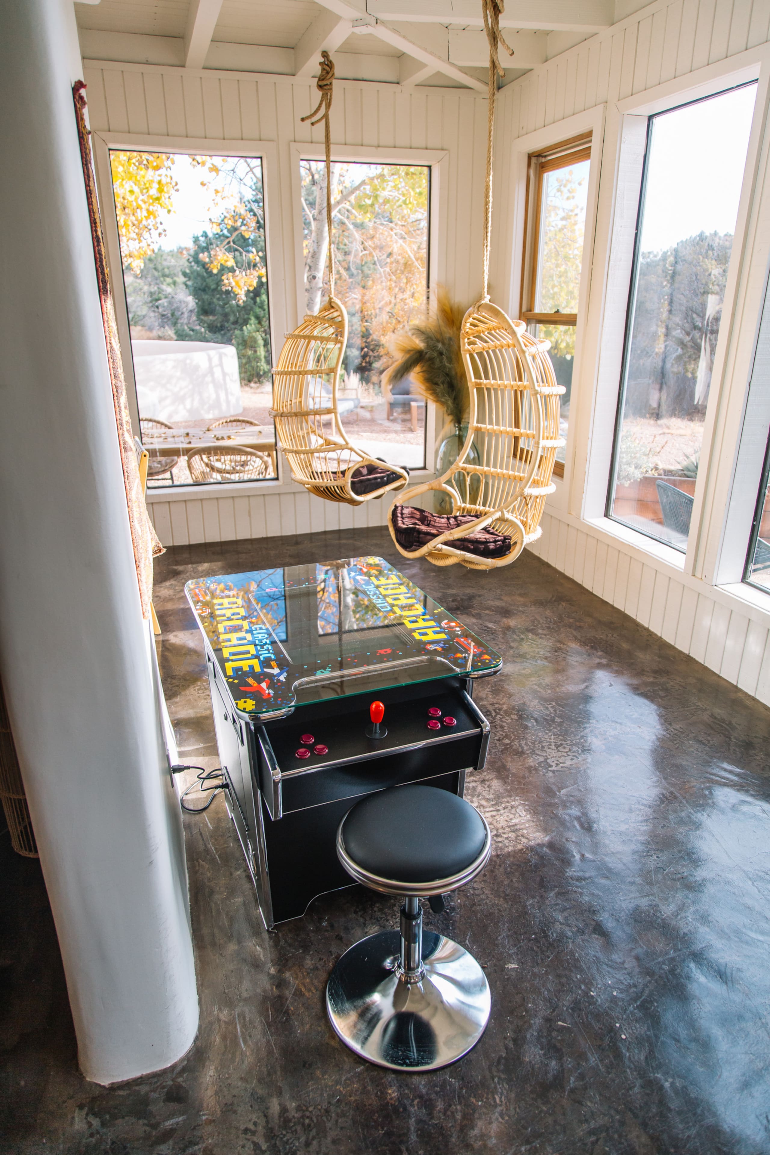 Vintage arcade cocktail cabinet with hanging rattan chairs