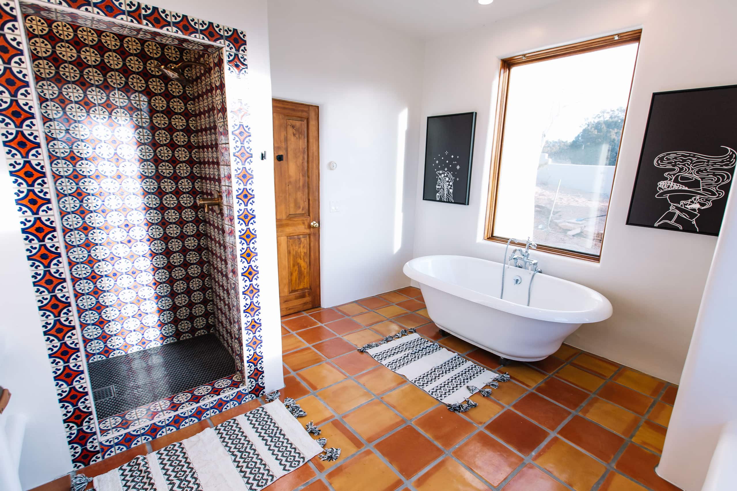 Bath with red-and-blue Talavera tile shower and freestanding tub