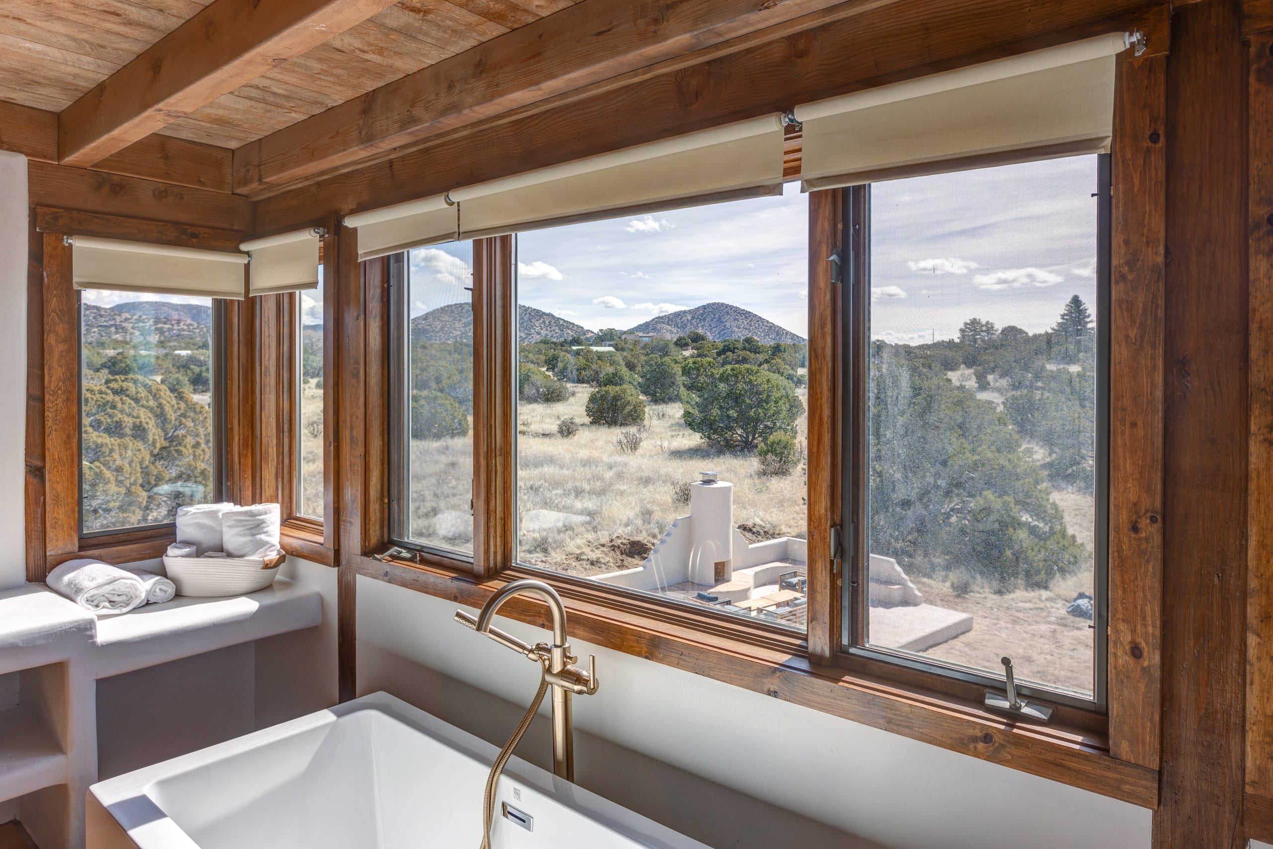 Soaking tub framed by picture windows with mountain views
