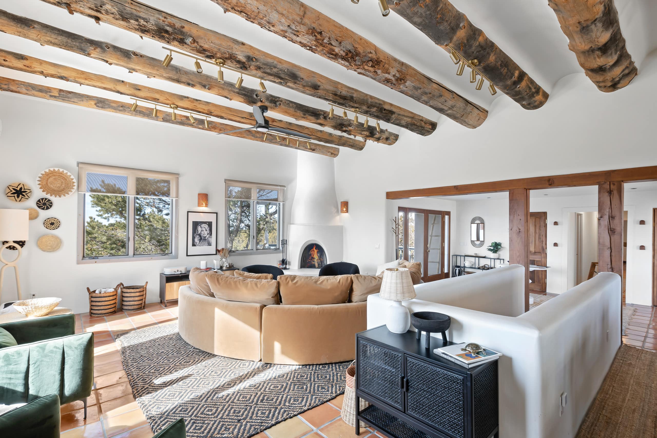 Casa de Camino great room with curved sectional and kiva fireplace
