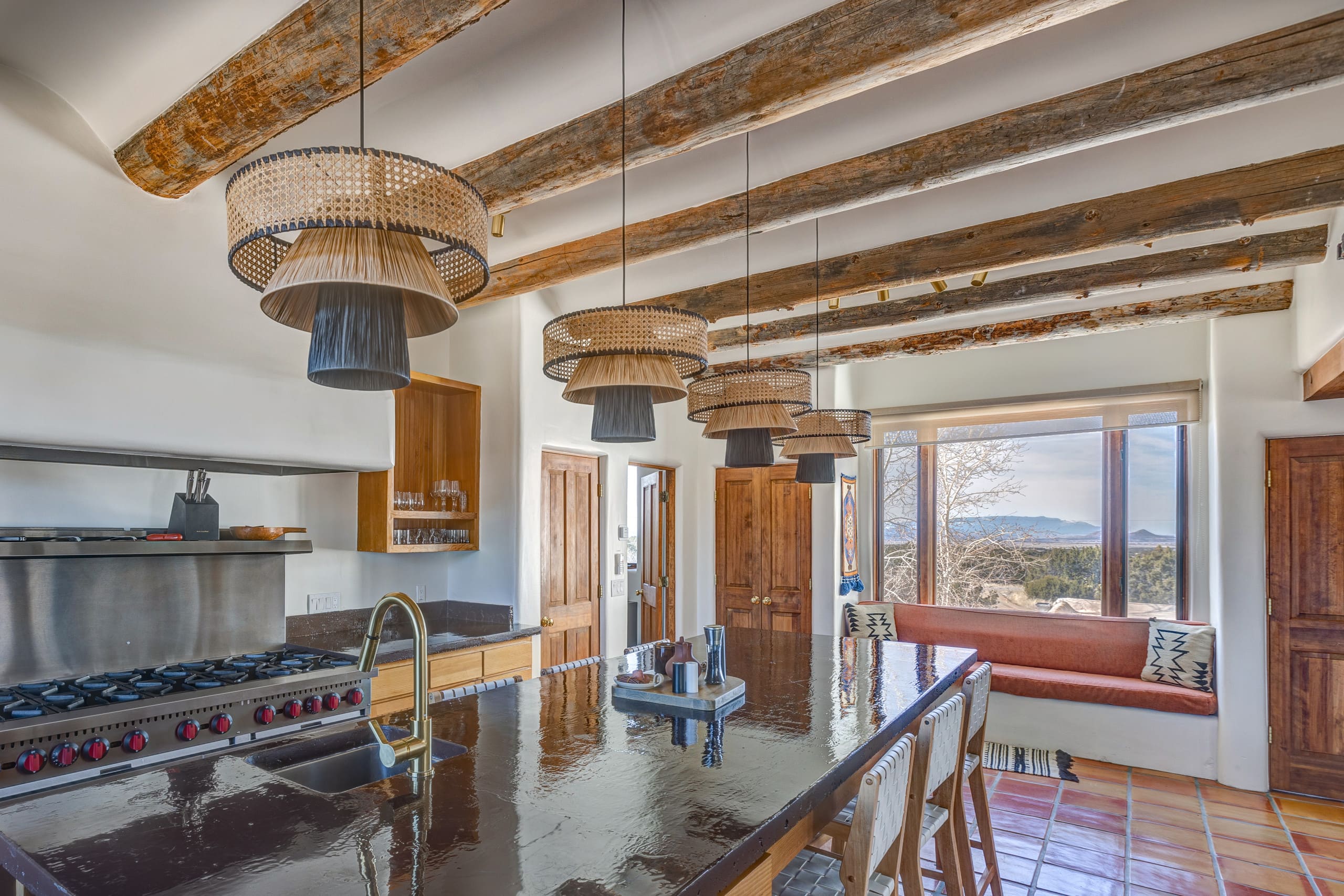 Kitchen from the range side with rattan pendants and window seat