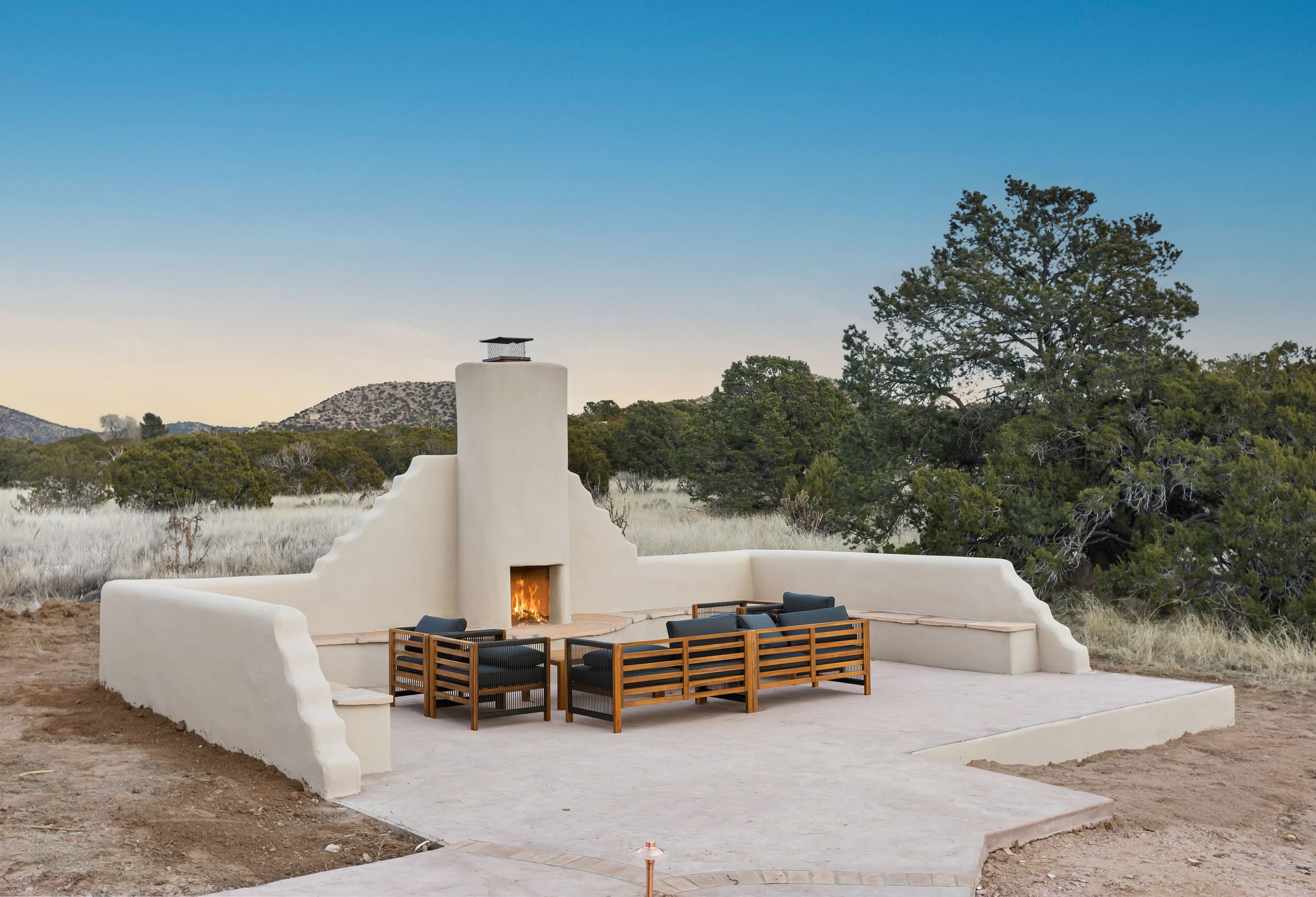 Outdoor kiva court at blue hour against the treeline