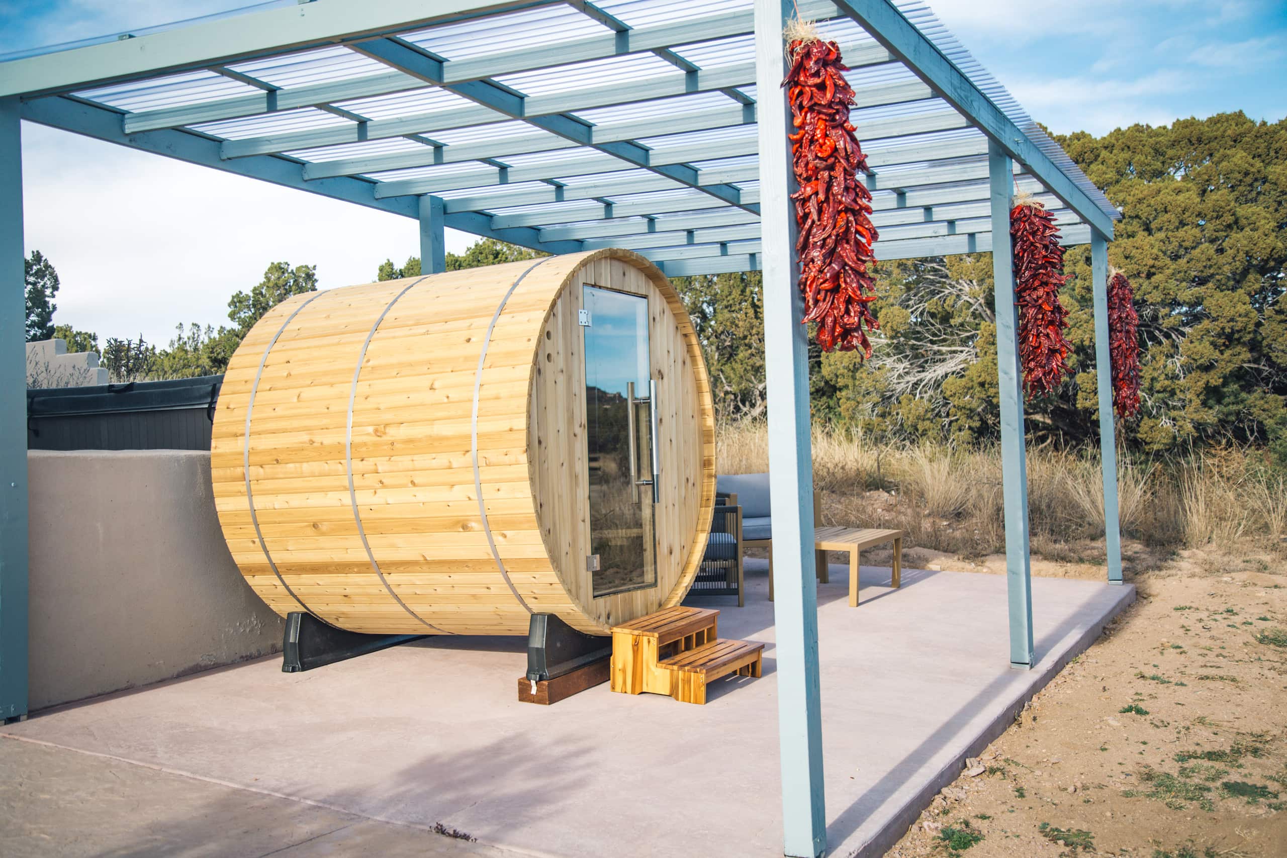 Barrel sauna under the pergola with chile ristras