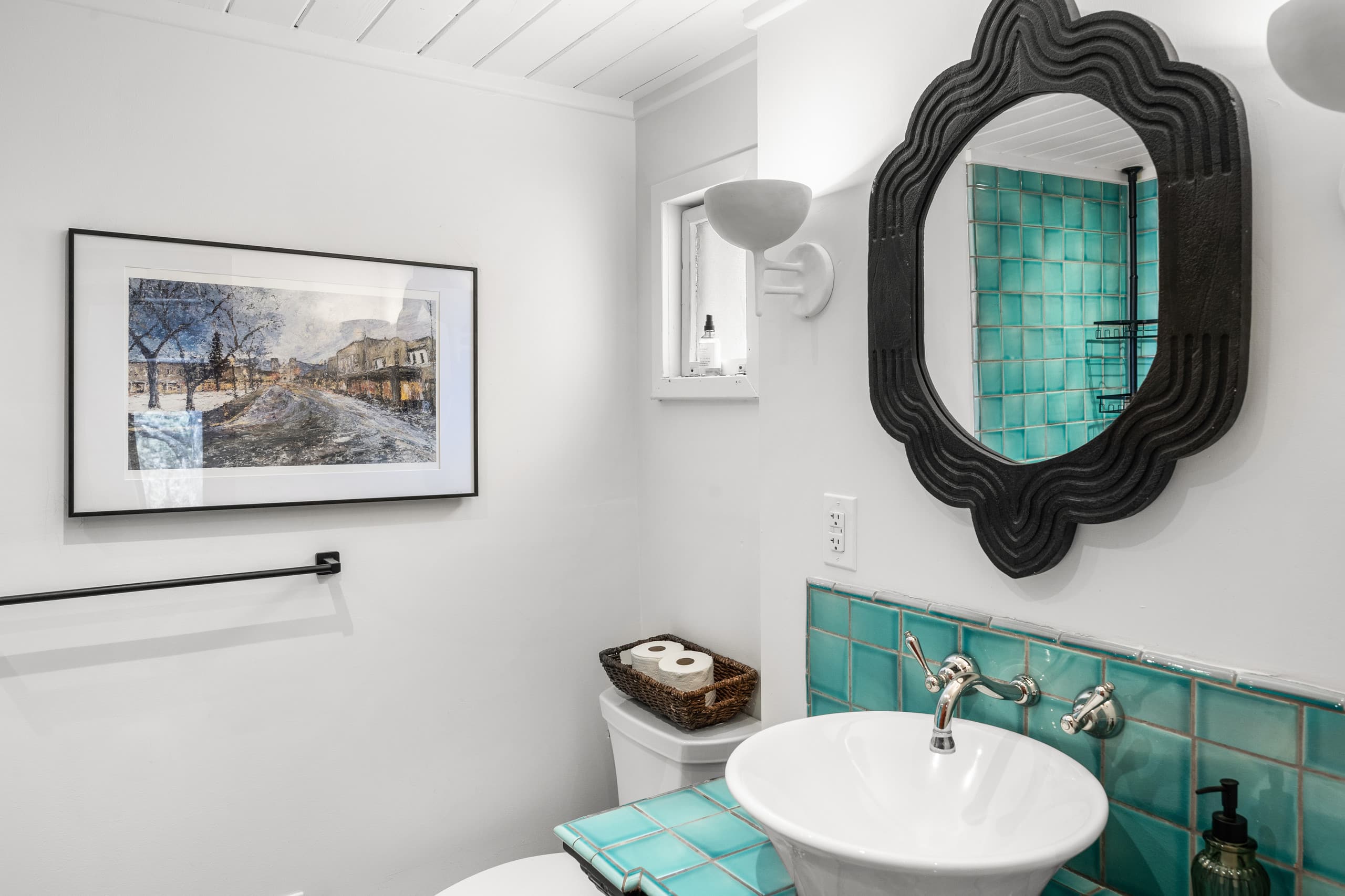 Powder bath with turquoise tile and black scalloped mirror