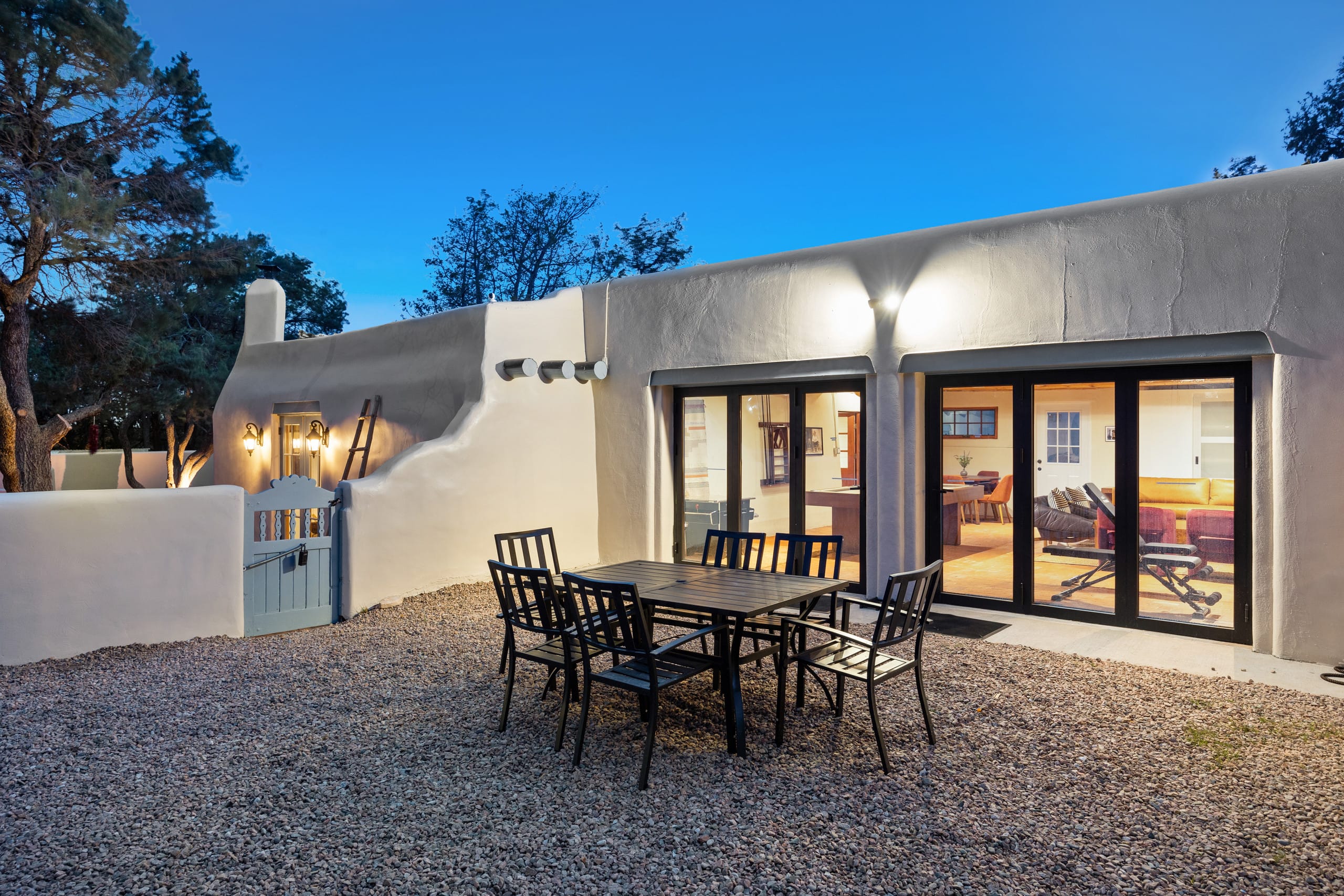 Casita patio at twilight with glowing doors and gravel terrace