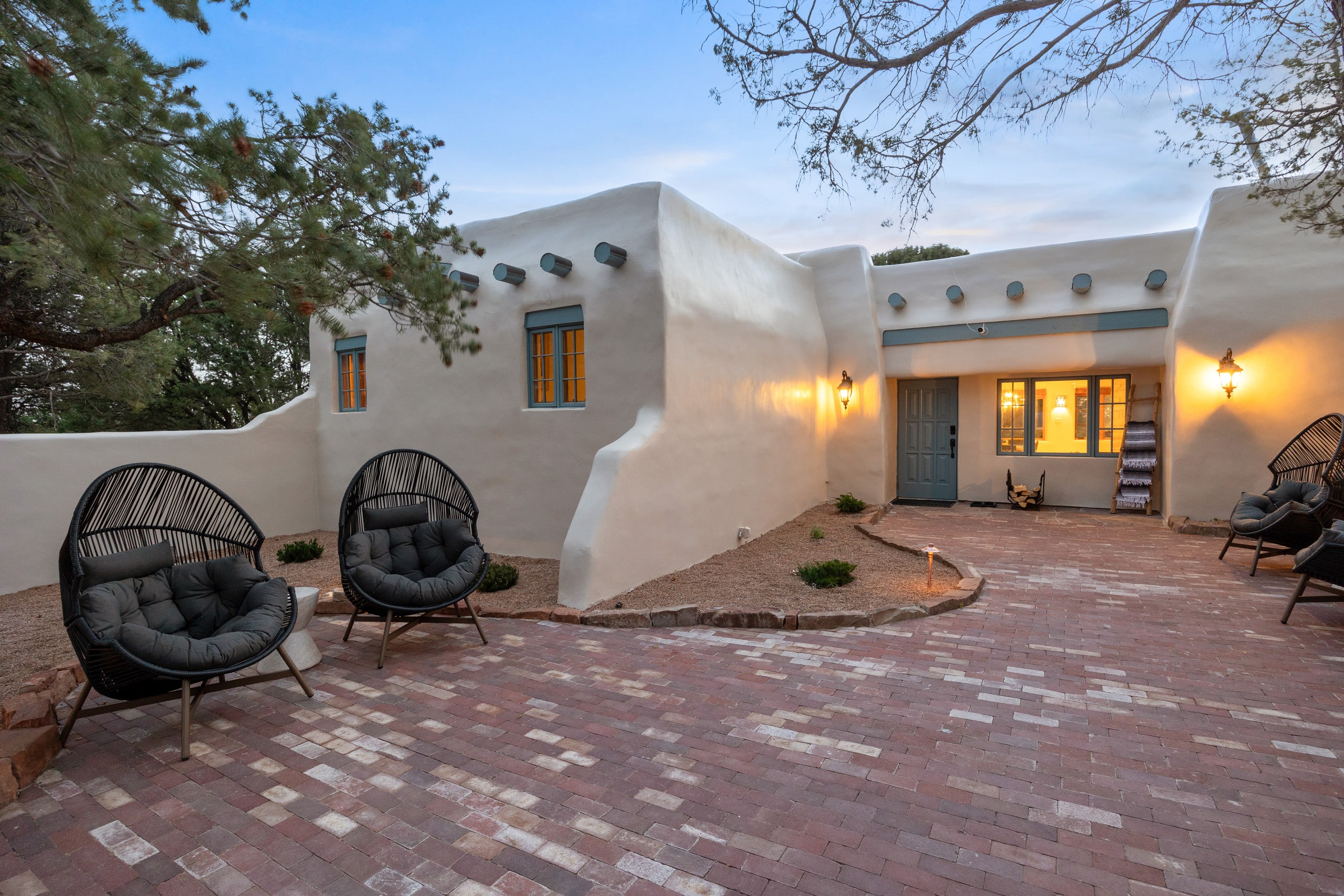 Front courtyard with hanging egg chairs at dusk