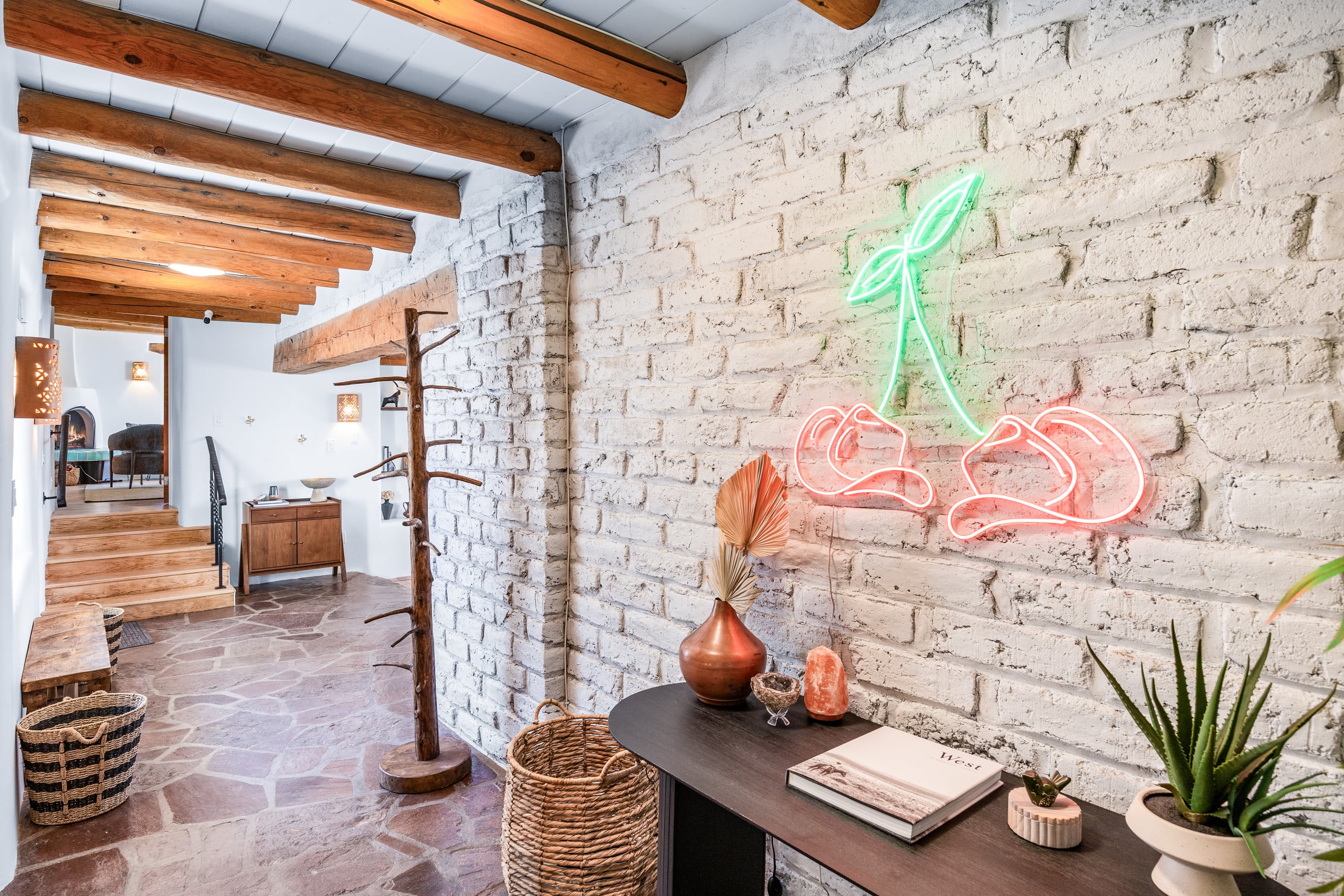 Entry hall with white brick, neon cherries art, and flagstone floor