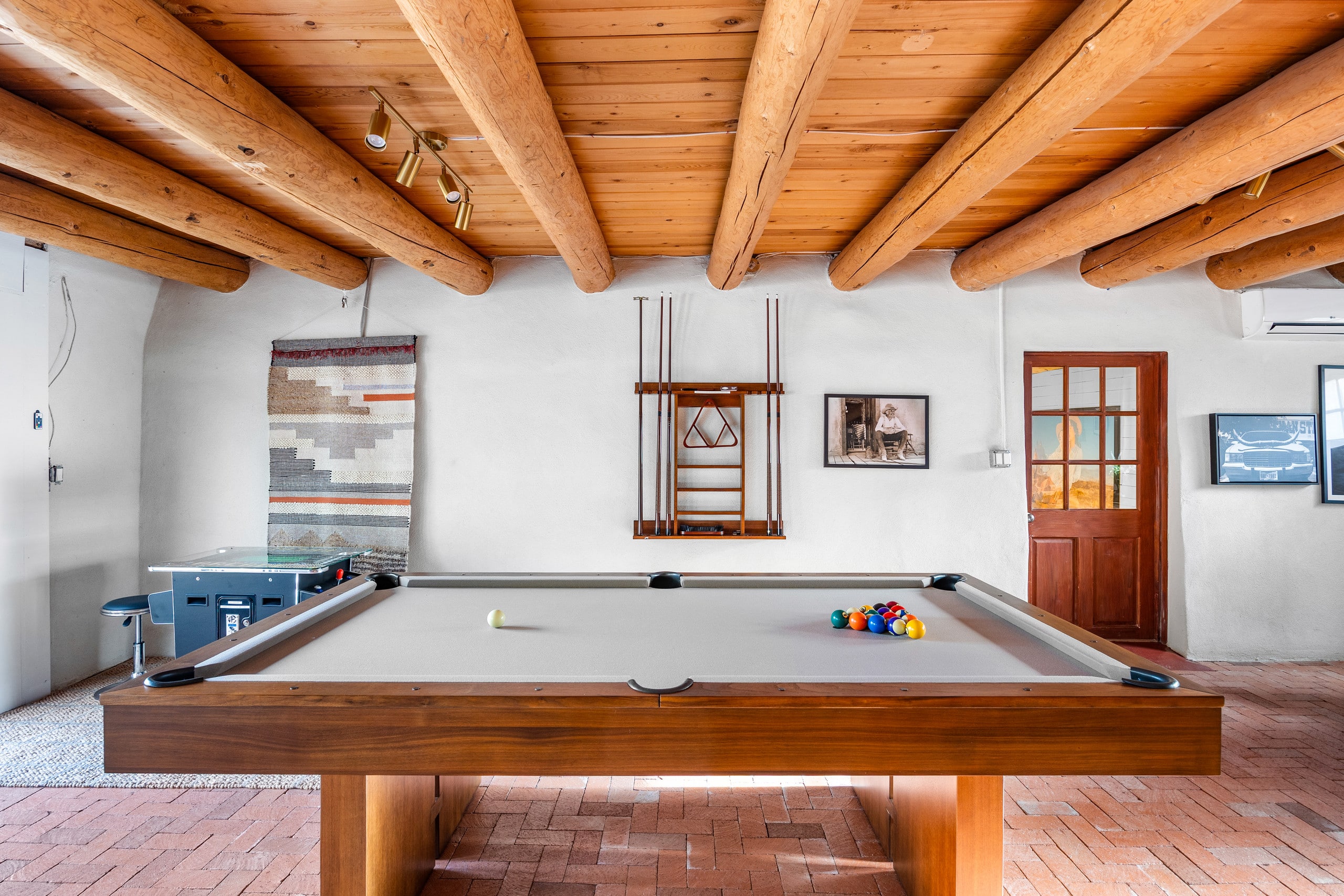 Game room with pool table, cue rack, and vintage arcade