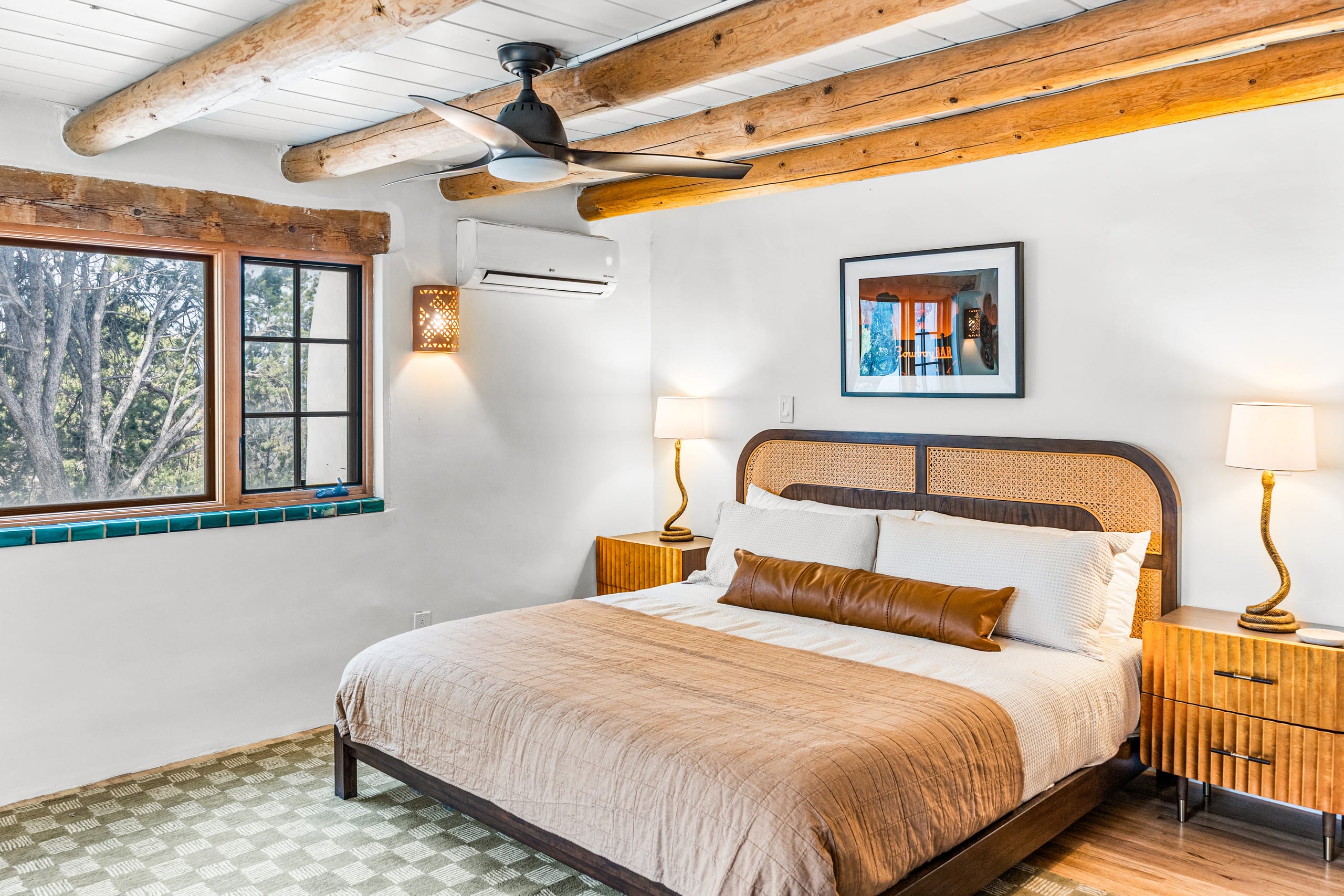 King bedroom with cane headboard and teal-tiled window sill
