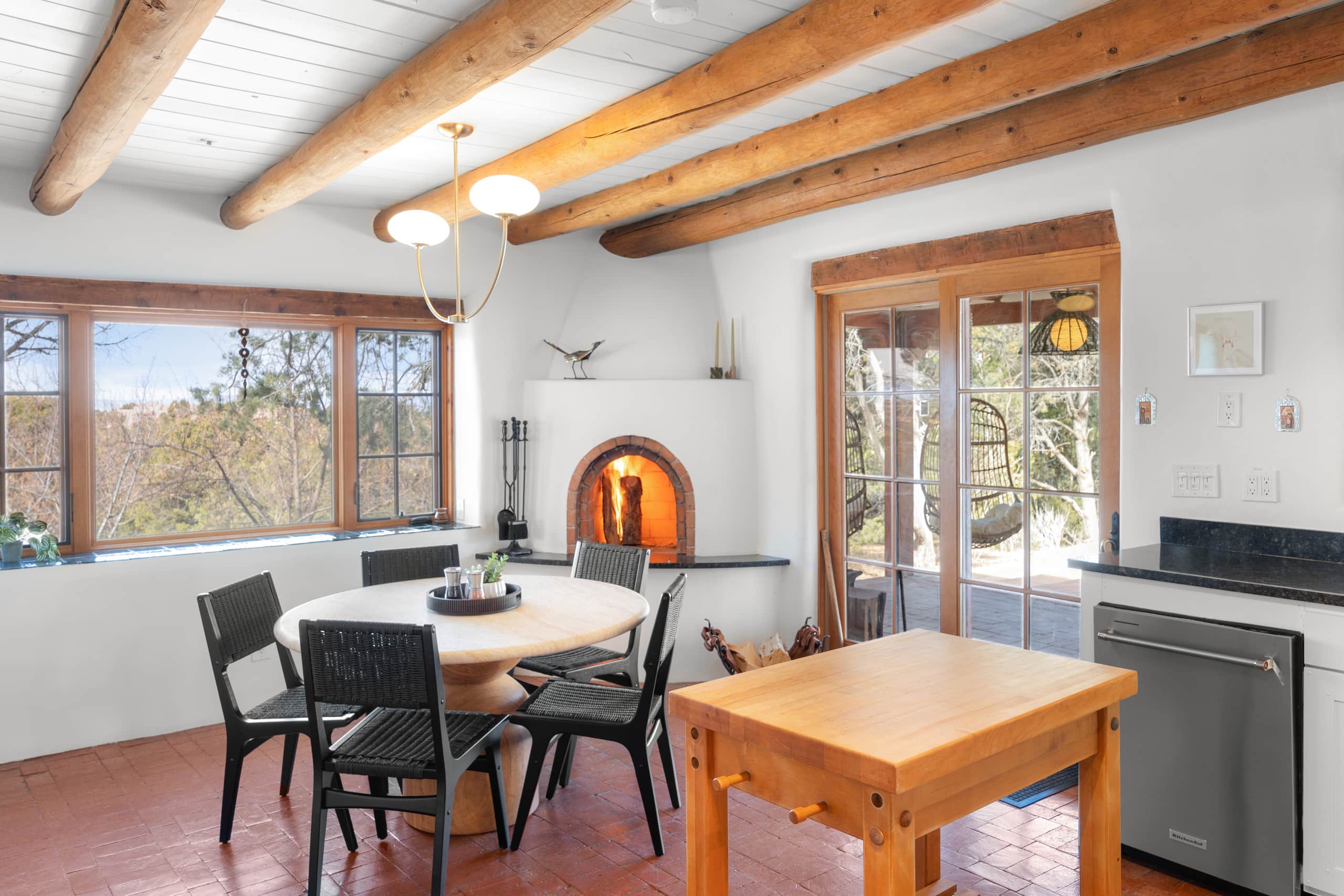 Breakfast nook with round table and lit kiva fireplace